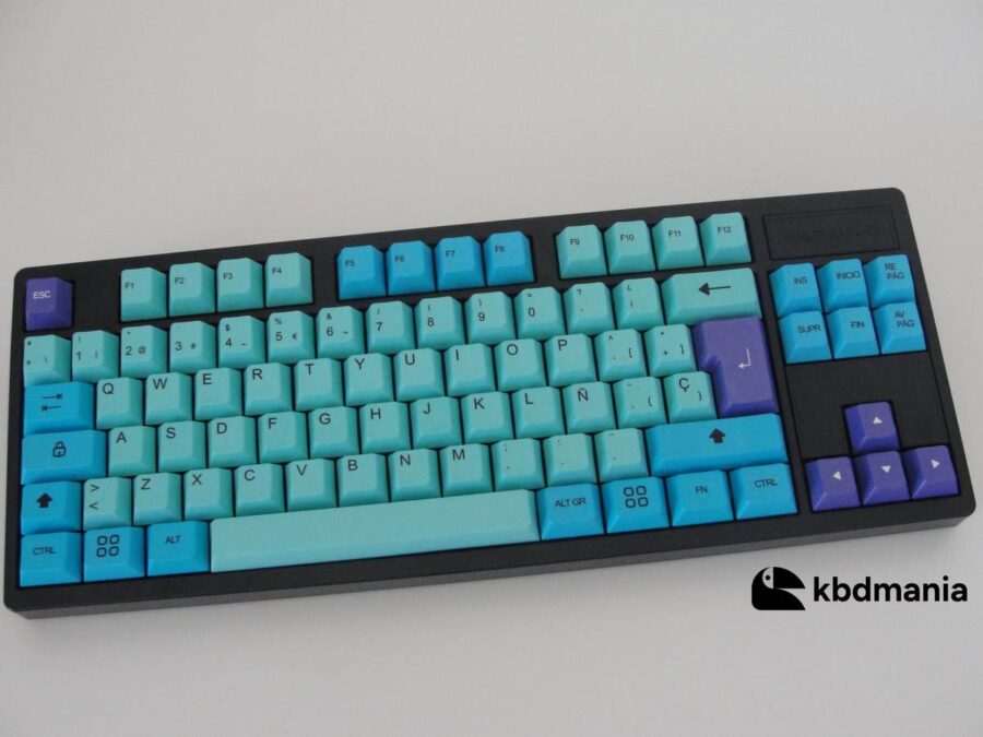 Keycaps en español, en colores turquesa, celeste y malva sobre un teclado negro ISO-TKL.