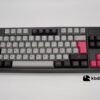 Set de keycaps español PBT, colores gris, negro y fucsia. Sobre un teclado negro ISO-TKL.