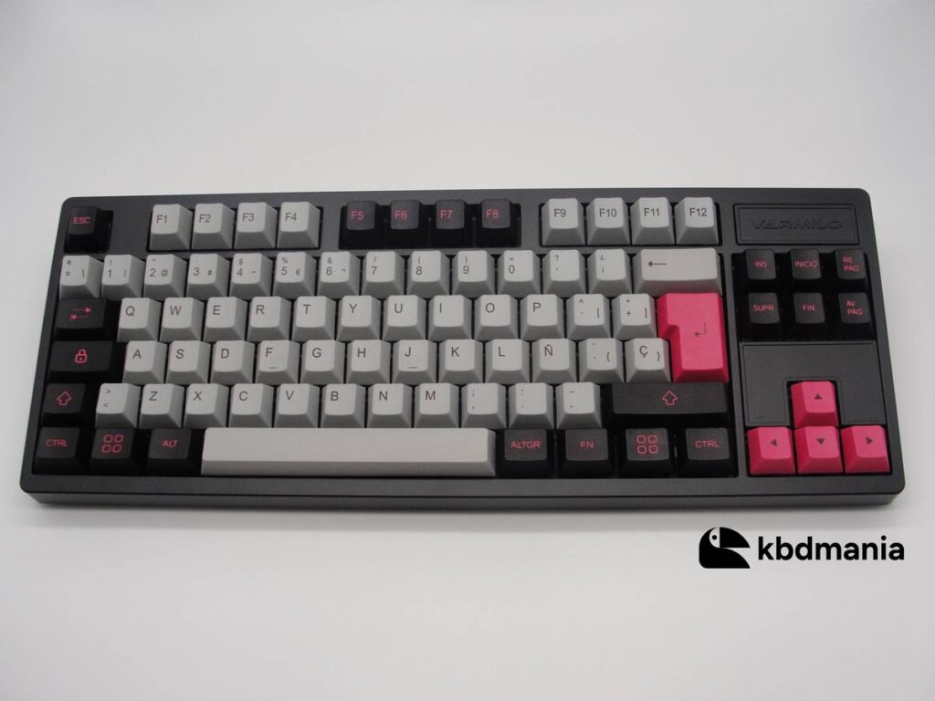 Set de keycaps español PBT, colores gris, negro y fucsia. Sobre un teclado negro ISO-TKL.