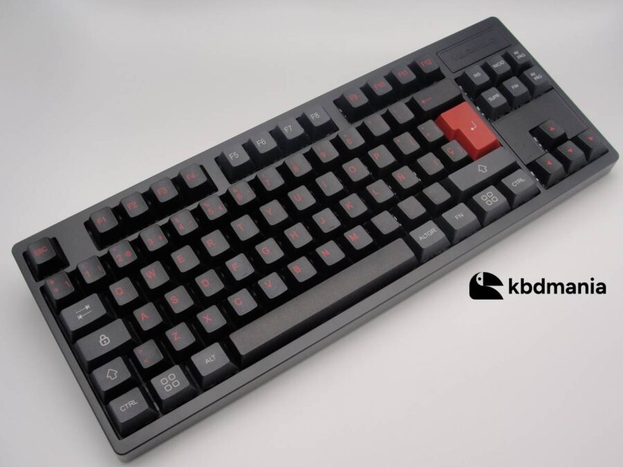 Keycaps español en colores negro, gris y rojo, sobre un teclado negro ISO-TKL.