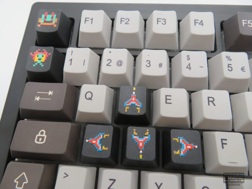 Keycaps extra WASD de kbdmania con naves shooter arcade pixelado. Foto frontal.