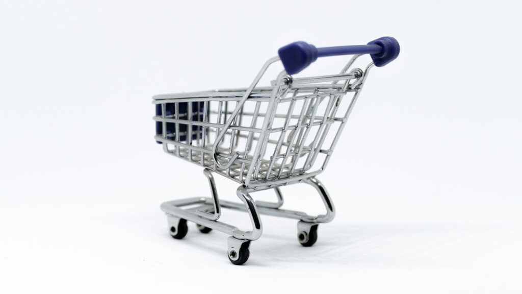 A close-up view of a miniature shopping cart on a white background.