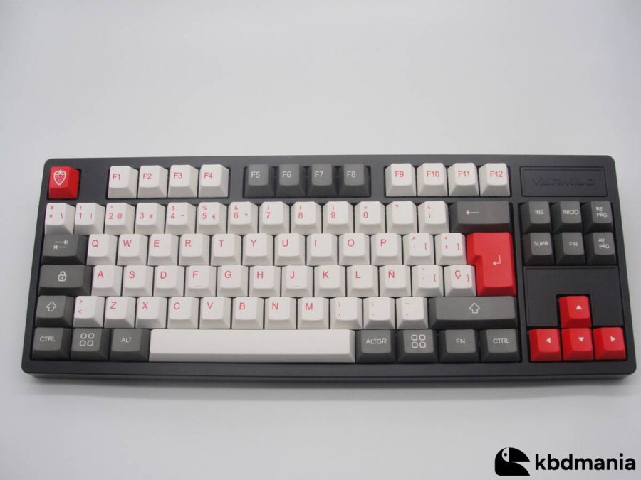 Set de keycaps en español, en colores blanco, gris y rojo. Sobre un teclado negro ISO-TKL.