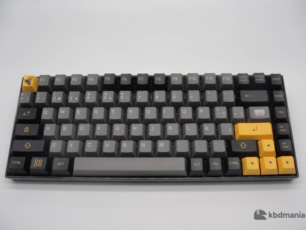 Set de keycaps español, colores gris, negro y mostaza. Sobre un teclado negro ANSI-75%