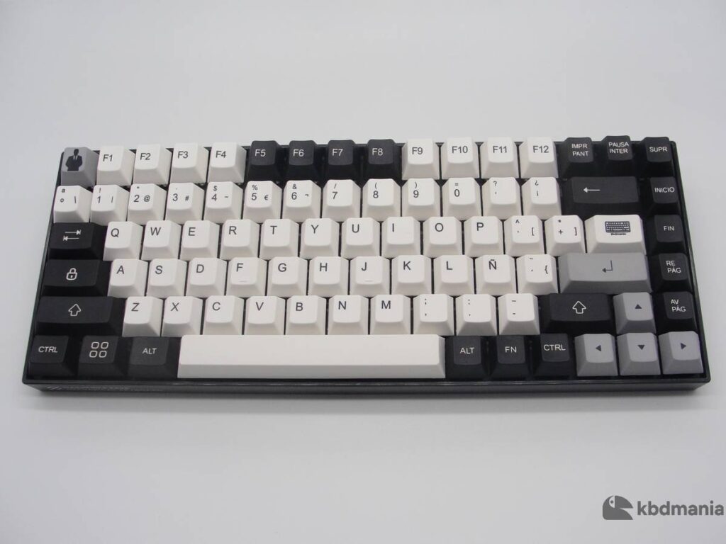 Set de keycaps español en colores blanco, negro y gris. Sobre un teclado negro ANSI-75%