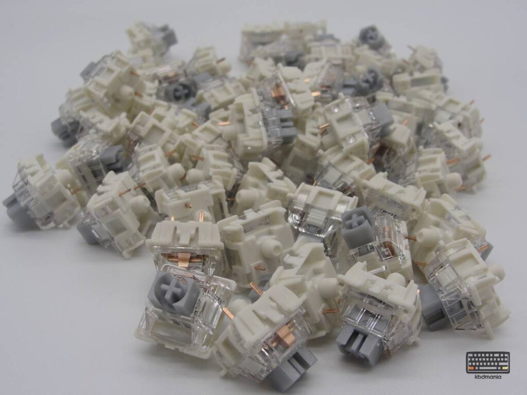 Conjunto de switches Gateron G Pro 3.0, stem gris, top transparente, bottom crema y 3 pines.