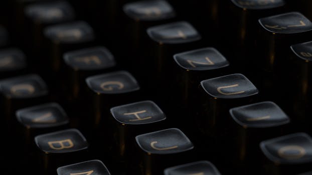 Artistic close-up of vintage typewriter keys highlighting letters with a shallow depth of field.