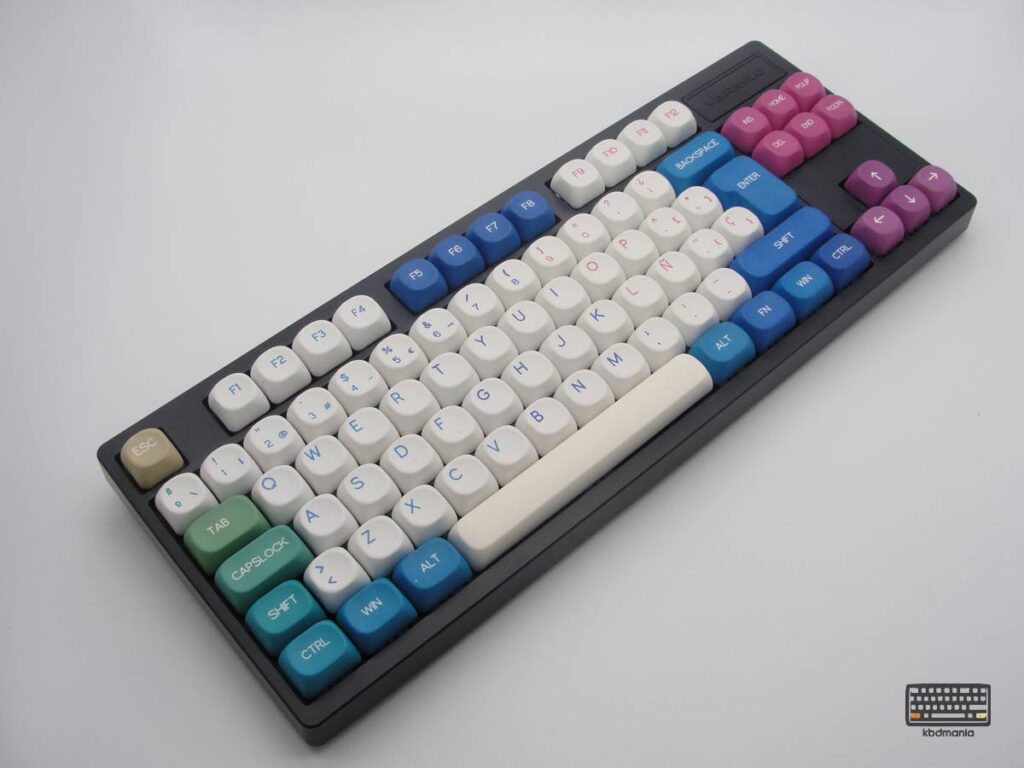 Teclas PBT redondeadas y uniformes de colores blancos y multicolor sobre un teclado negro ISO-TKL