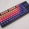 Teclas PBT uniformes y redondeadas en colores cálidos, sobre un teclado negro ISO-TKL, modelo SUN GLOW.