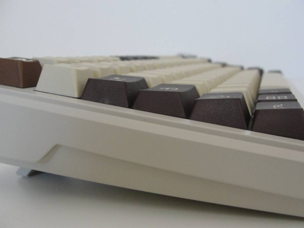 Vista perfil de teclas a diferentes alturas, en colores marrones. Sobre teclado beige, perfil cherry
